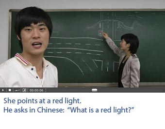Screenshot of a video with professional Chinese actors on which one sees what he hears. She points at a red light. He asks: What is a red light?